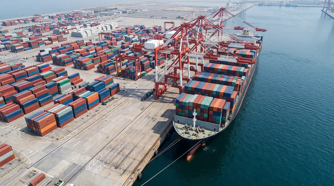 Container vessel berthed under gantry cranes at Shuwaikh Port commercial shipping terminal in Kuwait